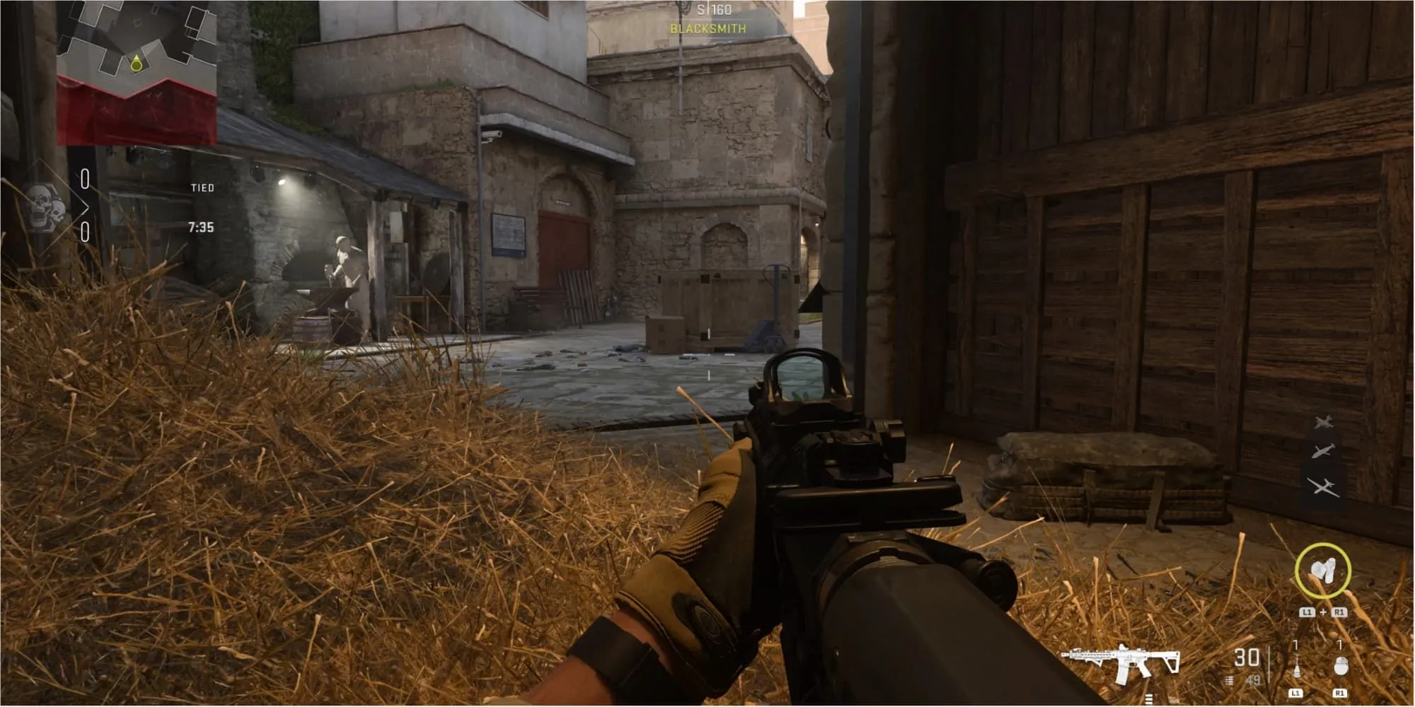 Một tay súng nằm sấp trong đống rơm tại chuồng ngựa của pháo đài Al Bagra trong Call of Duty: Modern Warfare 2.